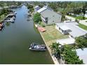 Waterfront property featuring a boat dock and canal access, with lush landscaping and a spacious yard at 13928 Raie Ave, Hudson, FL 34667