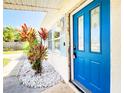 Charming home showcasing a bright blue front door and beautiful landscaping, offering a welcoming entrance at 13928 Raie Ave, Hudson, FL 34667