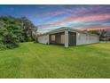 Back exterior view highlighting the screened lanai and well-maintained lawn, ideal for relaxation and entertainment at 14063 Wineberry Dr, Dade City, FL 33525