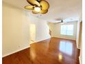 Hardwood floors and a ceiling fan adorn this light-filled living room, leading to the stairway and a dining area at 1427 Hillview Ln, Tarpon Springs, FL 34689