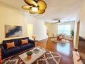 Bright living room features a ceiling fan, hardwood floors, and an adjacent dining area with views of the outdoors at 1427 Hillview Ln, Tarpon Springs, FL 34689
