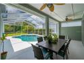 Covered outdoor dining area with views of screened in pool area and backyard, great for entertaining guests at 15309 Palomapark Ln, Lithia, FL 33547