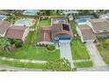 Aerial view of a landscaped home with pool and solar panels on the roof at 15609 Gardenside Ln, Tampa, FL 33624