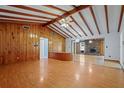 Spacious living room features wood paneling, wood beams, and hardwood floors, with an open layout at 1579 Palmetto St, Clearwater, FL 33755