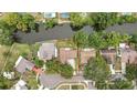Aerial view of a neatly platted neighborhood, featuring a home with a brown roof near waterfront at 17706 Morninghigh Dr, Lutz, FL 33549