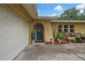 Inviting home exterior featuring a garage, stucco walls, and garden, creating a welcoming entrance at 17706 Morninghigh Dr, Lutz, FL 33549
