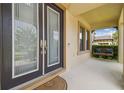 Welcoming front porch with double doors, covered area, and a cozy porch swing at 21797 Briske Morning Ave, Land O Lakes, FL 34637