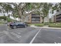 Designated parking area for a condo building, with mature trees and well-kept landscaping at 2500 Winding Creek Blvd # G307, Clearwater, FL 33761