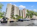 Condo building with balconies, guest parking, and well maintained landscaping at 2699 Seville Blvd # 207, Clearwater, FL 33764