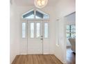 Bright foyer featuring a decorative glass front door, modern light fixture, and wood-look flooring at 27466 Tierra Del Fuego Cir, Punta Gorda, FL 33983