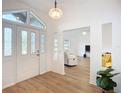 Bright foyer features a decorative glass front door, modern light fixture, and wood-look flooring at 27466 Tierra Del Fuego Cir, Punta Gorda, FL 33983