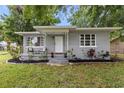 Charming single-story home features a cozy front porch with seating and manicured landscaping at 2902 W Lemon St, Tampa, FL 33609