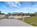 Single-story home with blue siding, stone accents, grey driveway and walkway at 3204 Dodge St, Tampa, FL 33605