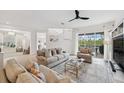Bright living room with neutral decor, comfortable seating, and large windows offering pool views at 32490 Tree Of Life Ave, Wesley Chapel, FL 33543