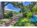 Inviting backyard with lush landscaping, brick pathway, cozy seating, providing an ideal outdoor retreat at 4742 13Th N Ave, St Petersburg, FL 33713