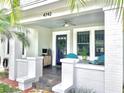 Charming front porch featuring brick columns, comfortable seating and a welcoming blue door with wreath at 4742 13Th N Ave, St Petersburg, FL 33713