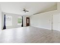 Bright living room with high ceilings, tile floors, two windows and a ceiling fan at 4959 Cromey Rd, North Port, FL 34288