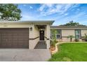 Close up of the house showing well-maintained landscaping, updated exterior paint, and a dark colored front door at 5015 Summer Hill Dr, Zephyrhills, FL 33542