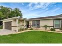 Landscaped front yard with updated paint and garage door is accented by a luscious green lawn at 5015 Summer Hill Dr, Zephyrhills, FL 33542