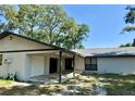 Single-story home showcasing a covered entry, one-car garage, and mature trees with a lush yard at 5614 Kenny Dr, Tampa, FL 33617