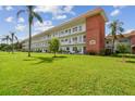 Three-story condo building with brick facade, white accents, and landscaped green lawn with palm trees at 5728 14Th N Ave # 101B, St Petersburg, FL 33710