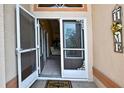 Inviting front entrance featuring a decorative storm door and 'HOME' welcome sign at 6121 Piedmont Dr, Spring Hill, FL 34606