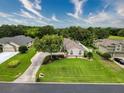 Expansive home featuring manicured lawns, mature trees, and a long driveway, nestled in a lush green neighborhood under a bright sky at 6204 Rockross Ave, New Port Richey, FL 34655