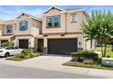 Beautiful townhome with a dark two-car garage, lush landscaping, and blue shutter accents at 6711 Rocky Park St, Tampa, FL 33625