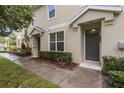 Townhouse entrance showcasing a well-kept walkway, tidy landscaping, and a gray front door at 7001 Interbay Blvd # 242, Tampa, FL 33616