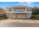 Three-story townhouse featuring a balcony above stone-accented three-car garages on a sunny day at 7001 Interbay Blvd # 242, Tampa, FL 33616