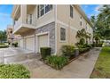 Side view of a townhome featuring a three-car garage, stone accents, and well-maintained landscaping at 7001 Interbay Blvd # 242, Tampa, FL 33616