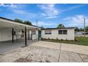 Angle view of house showing white exterior, carport, and blue front door at 7524 Tidewater Trl, Tampa, FL 33619