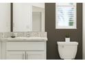 Elegant bathroom featuring a white vanity with a countertop and a modern toilet at 10113 Trumpet Honetsuckle Way, San Antonio, FL 33576
