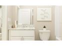 Bright bathroom features a white vanity with a granite countertop and minimalist artwork at 10186 Trumpet Honeysuckle Way, San Antonio, FL 33576