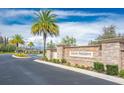 Entrance to Heron Preserve, featuring stone signage, colorful flowers, and palm trees at 10707 Pegasus Valley Ct, Tampa, FL 33647