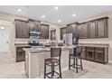 Modern kitchen boasts granite countertops, dark wood cabinets, and stainless steel appliances at 10707 Pegasus Valley Ct, Tampa, FL 33647