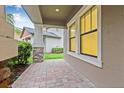 Covered patio featuring brick pavers, stone accents, and a view of the manicured backyard at 10707 Pegasus Valley Ct, Tampa, FL 33647