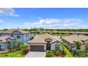 Well-maintained home featuring a two-car garage, lush landscaping, and a tranquil pond view at 11100 Balfour St, Venice, FL 34293