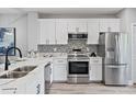 Modern white kitchen featuring stainless steel appliances, tile backsplash, and marble countertops at 11510 Shipwatch Dr # 1372, Largo, FL 33774
