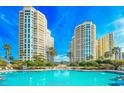 Beautiful swimming pool with towering condominium buildings and verdant landscaping at 1170 Gulf Blvd # 1006, Clearwater Beach, FL 33767