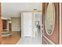 Inviting entryway showcasing tile flooring and a decorative front door, leading to living and dining areas at 12101 Meadowbrook Ln, Hudson, FL 34667