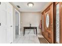 Bright foyer with tile flooring, a wooden front door with glass, and a classic console table at 12101 Meadowbrook Ln, Hudson, FL 34667