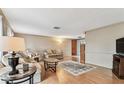 Cozy living room with hardwood floors, neutral paint, comfortable seating, and a decorative rug at 12101 Meadowbrook Ln, Hudson, FL 34667
