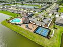 Aerial view showcasing the community pool, tennis courts, playground, and surrounding homes and ponds at 12382 Shining Willow St, Riverview, FL 33579
