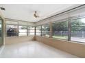 Enclosed patio features many windows, neutral paint, and a ceiling fan at 13898 Jamaica Dr, Seminole, FL 33776