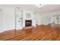 Spacious living room featuring hardwood floors, a brick fireplace, and bookshelves at 13917 8Th St, Dade City, FL 33525