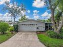 Well-maintained two-car garage with an extended driveway, lush landscaping and mature trees in a residential neighborhood at 140 Morrow Cir, Brandon, FL 33510