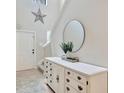 Bright foyer with a decorative star, a round mirror, and an elegant white dresser at 14716 Crescent Rock Dr, Wimauma, FL 33598