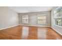 Bright bedroom with wood floors, large windows, and neutral walls at 15709 Leatherleaf Ln, Land O Lakes, FL 34638