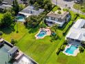 Beautiful aerial shot of home with large green lawn, pool, dock, and waterfront access at 224 Harbor View Ln, Largo, FL 33770